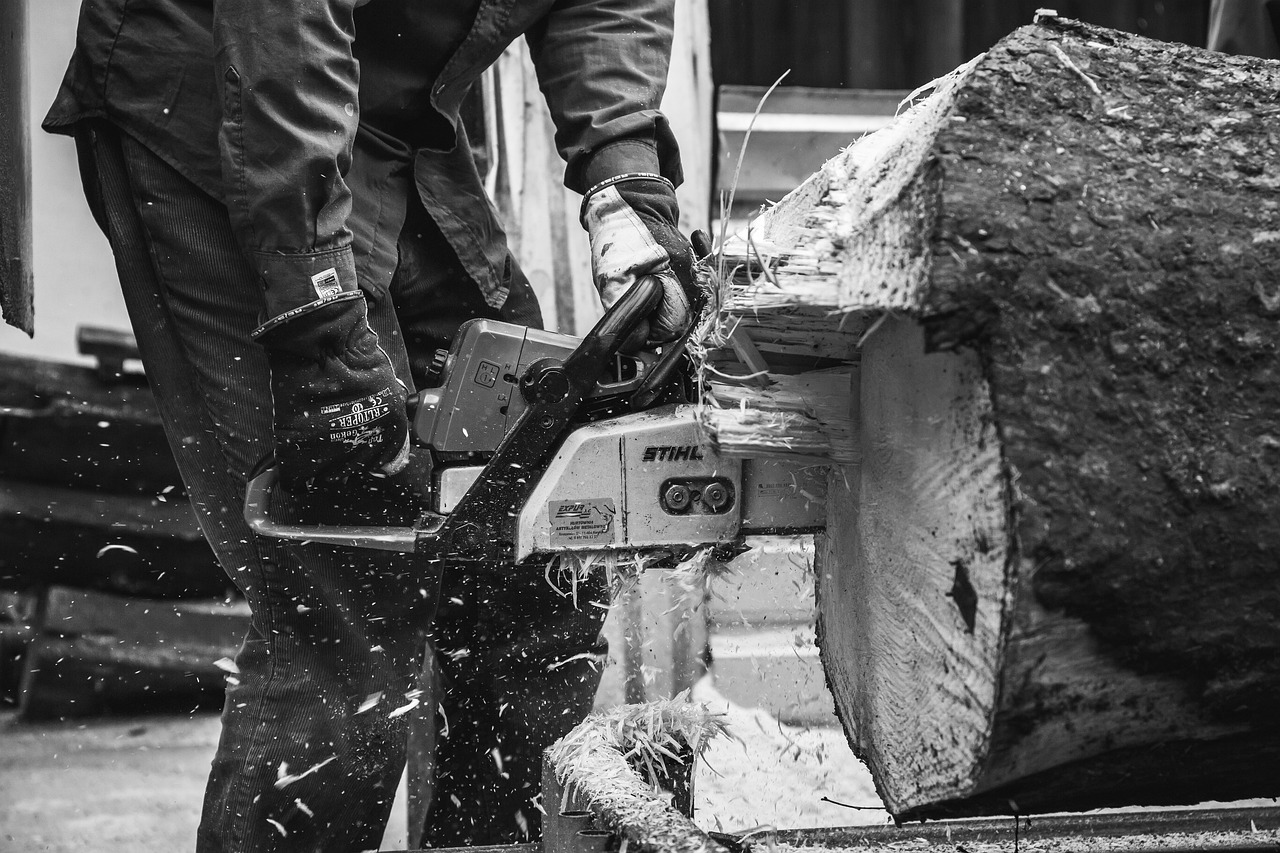 A man operating a chainsaw, focused and skilled
